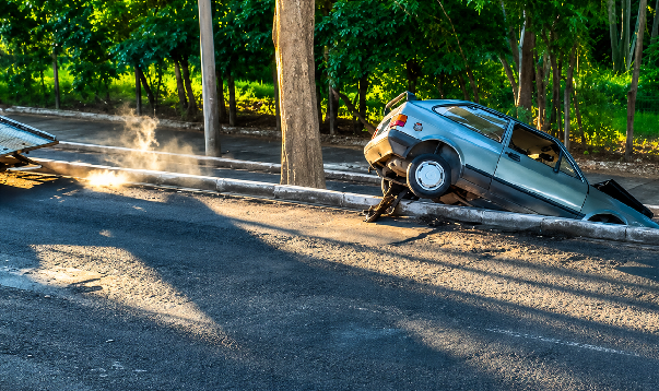 Carro perde o controle e fica pendurado em canteiro central da Avenida dos Fundadores